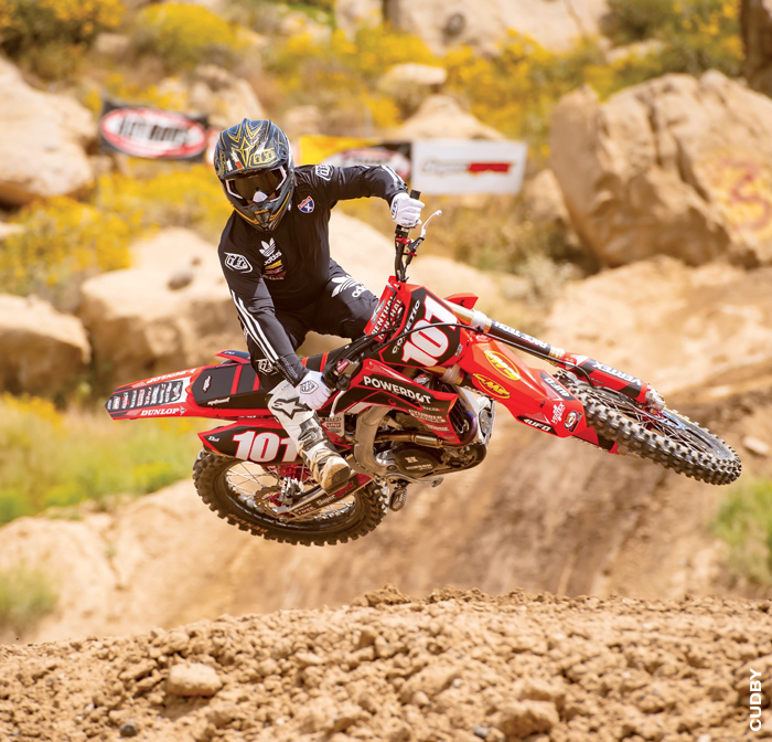 RacerX Rider jumping over dirt hill